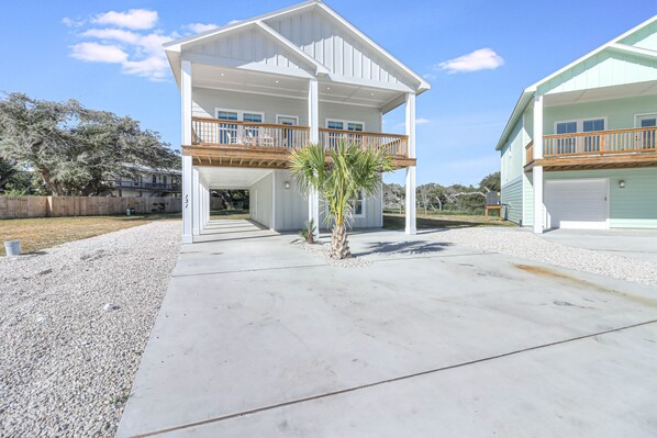 Enjoy a home away from home in this two-story house with a covered front porch and upper-level balcony.