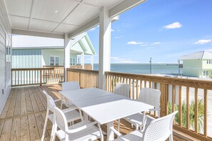 Enjoy the serene ocean views from this expansive outdoor deck with a table and chairs.