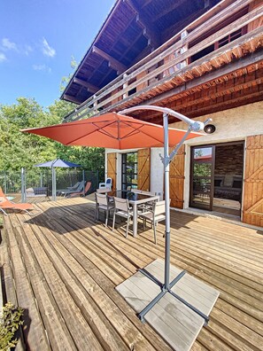 Relax on the deck with a glass table and comfortable chairs under a shaded area.