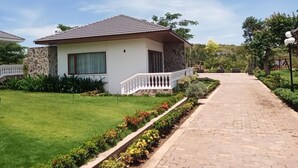 A single-story house with a tiled roof, a white exterior, and a small porch with a white railing. - Resort Đá Bàng Homestay & Restaurant (Ho Chi Minh City)