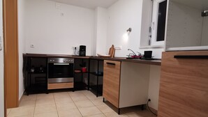 A modern kitchen with a built-in oven, a coffee machine, and a wooden countertop. - [r]auszeit, 65 qm Apartment, für Wanderlustige und Stadtbummler (Nittendorf)