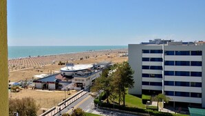 Un hôtel situé sur la côte, avec vue sur la plage, une station-service et un immeuble à plusieurs étages.