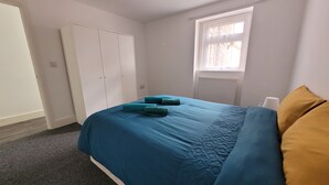 Une chambre à coucher avec un lit, une armoire, une fenêtre et un radiateur.