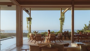 Un grand espace extérieur aménagé avec des chaises et une table, offrant une vue sur la mer.