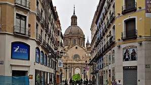 Una plaza mojada con un edificio central que tiene una cúpula y una cruz.