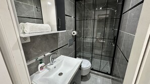 Basic Apartment | Bathroom | Shower, rainfall showerhead, slippers, towels