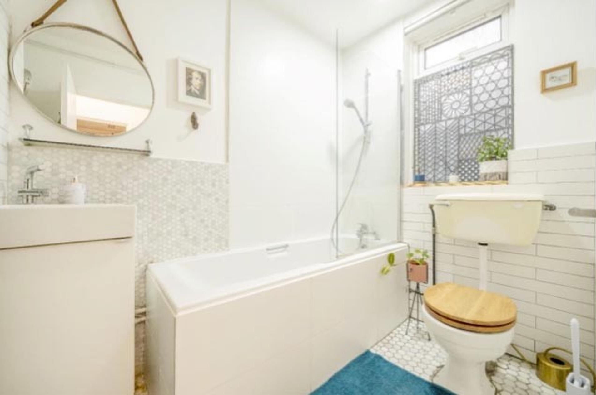 A bathroom with a bathtub, toilet, sink, and a mirror.