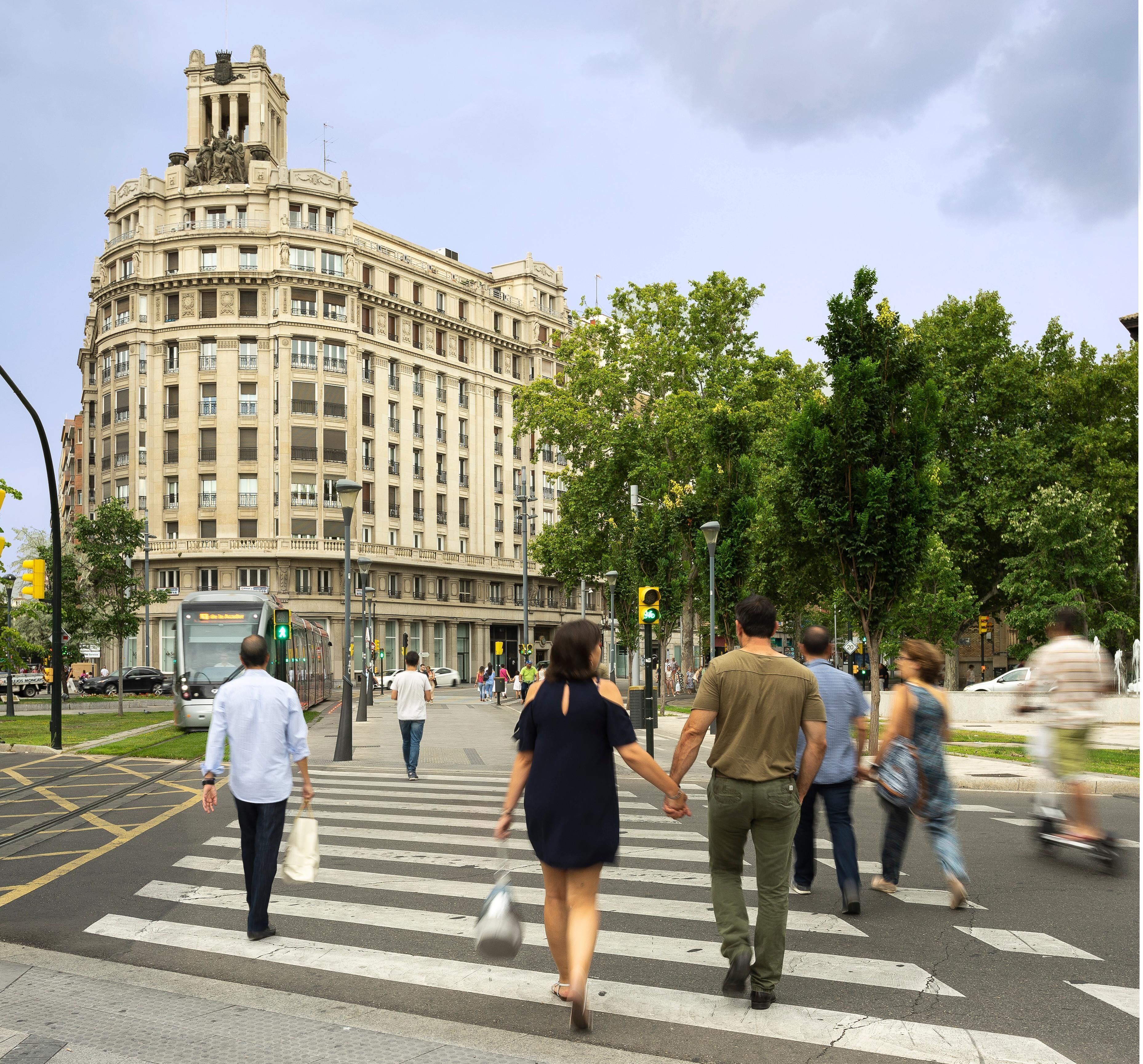 Un passage piéton avec, en arrière-plan, un grand bâtiment historique.
