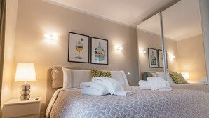 A neatly made bed with folded towels, a bedside lamp, and framed artwork on the wall. - AM LUXURY HOME IN PUERTO RICO (Mogán)
