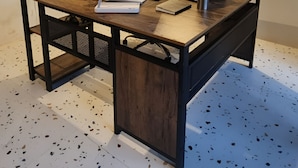 Un espacio de trabajo con un escritorio de madera, una computadora y un monitor.
