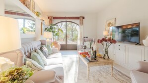 A well-lit living room with a sofa, coffee table, and TV. - Villa Amore, a Romantic Hilltop Farmhouse in Lucca (Lucca)