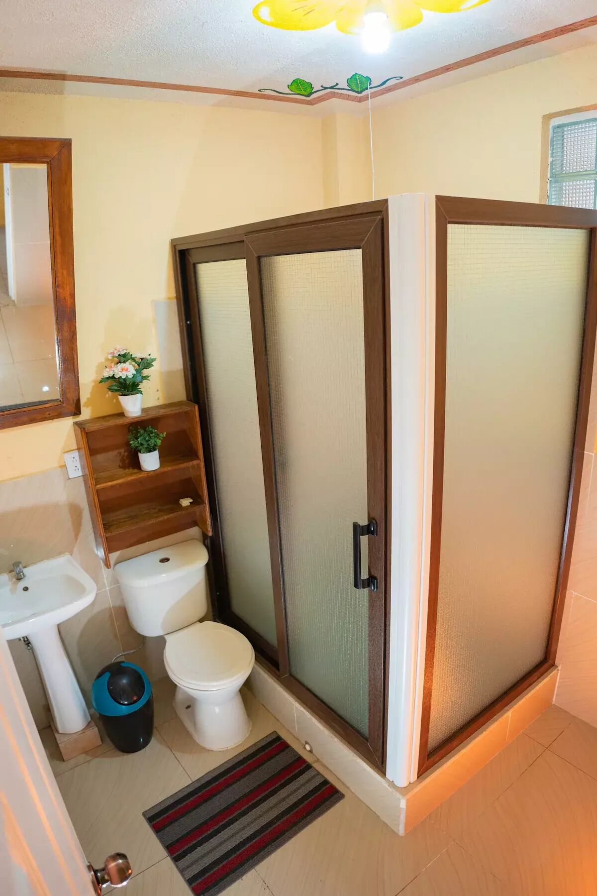 Ein Badezimmer mit Toilette, Bidet, Waschbecken und einer Duschkabine mit Glastür.