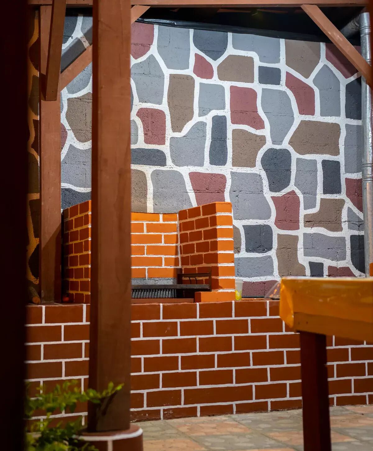 A brick wall with a stone pattern and a brick fireplace.