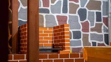 A brick wall with a stone pattern and a brick fireplace.