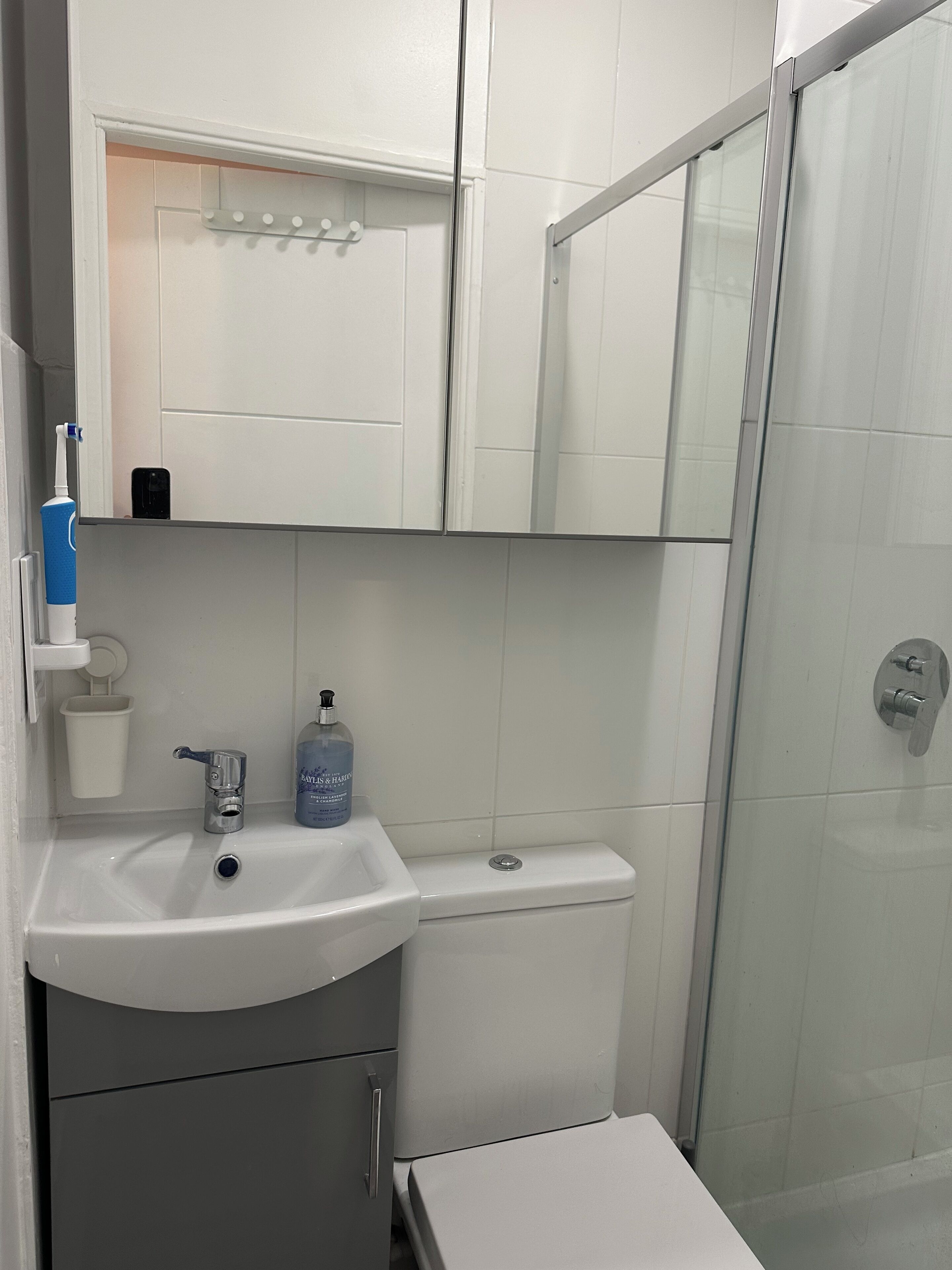 A bathroom with a white sink, a toilet, and a glass shower enclosure.