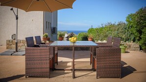 An outdoor dining area with wicker furniture, a glass table, and a beige umbrella. - Rena Bianca, 25 m2, 6 min walk to the beach! (Coggia)