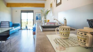 A kitchen with a coffee table, two decorative mugs, and a framed picture on the wall. - Rena Bianca, 25 m2, 6 min walk to the beach! (Coggia)