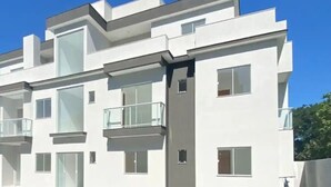 Un edificio moderno de varios pisos con balcones y ventanas grandes.