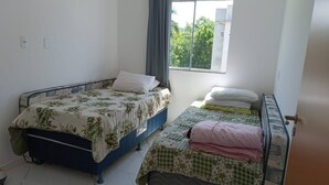 Una habitación con dos camas, una con edredón floral y la otra con diseño de cuadros.