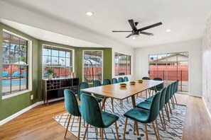 A dining area with a long table, teal chairs, and a ceiling fan. - Heated Pool, Volleyball, Pickleball, Hot Tub! Oasis Resort (Scottsdale)