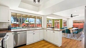 A modern kitchen with white cabinets, a dishwasher, and a view of a pool area. - Heated Pool, Volleyball, Pickleball, Hot Tub! Oasis Resort (Scottsdale)