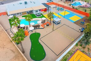 A pool area with a hot tub, lounge chairs, and a tennis court. - Heated Pool, Volleyball, Pickleball, Hot Tub! Oasis Resort (Scottsdale)