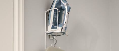 A wall-mounted ironing board with a protective cover.