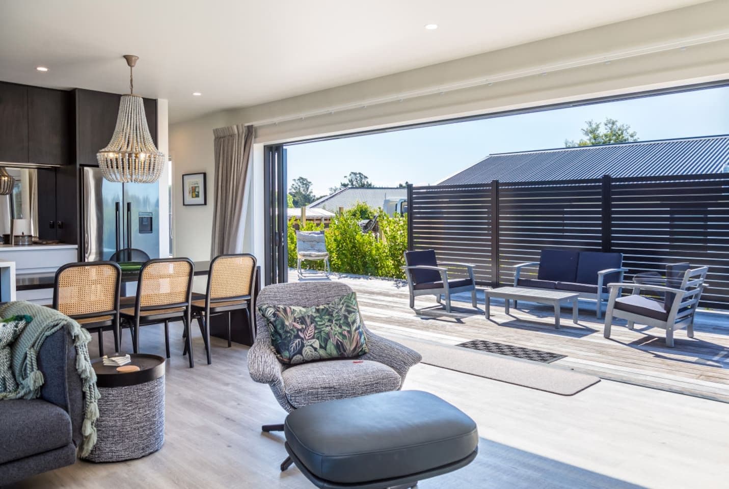 Una sala de estar moderna con comedor, ventanas amplias y vistas al exterior.