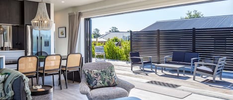 Una sala de estar moderna con comedor, ventanas amplias y vistas al exterior.