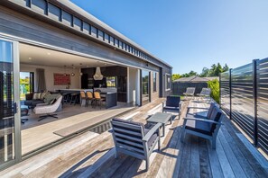 A modern house with an open-plan living area, a kitchen, and a deck with outdoor furniture. - Vinebox on Wilson, Martinborough (Martinborough)