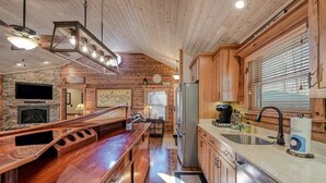 A spacious kitchen with wooden cabinets, a built-in stove, and a large island with bar seating.