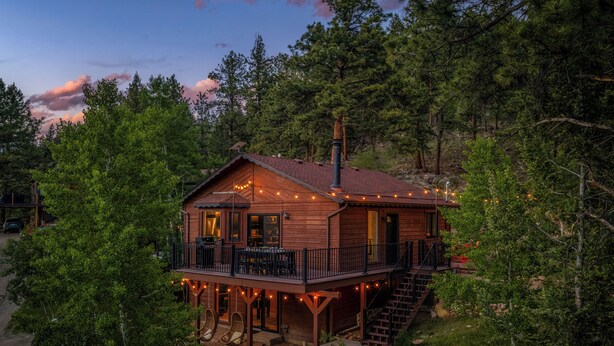 A wooden cabin with a deck, outdoor seating, and a chimney. - NEW Hot Tub + Arcade + Fire Pit + Mtn Views (Bailey)