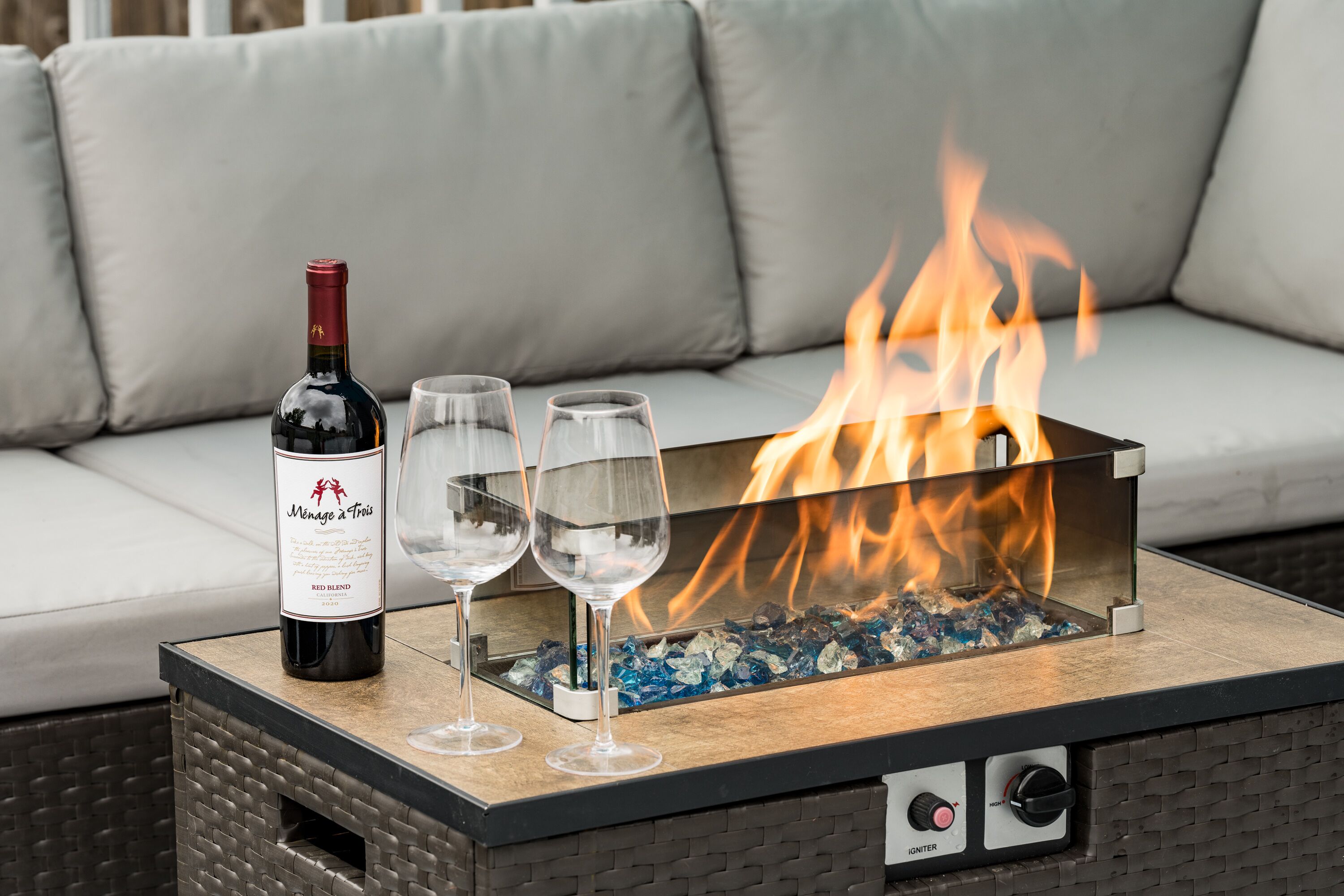 Un foyer, une bouteille de vin et des verres disposés sur une table.
