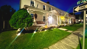 A two-story house with a porch, a small tree in front, and a street sign indicating 'Main' and 'Estella'.