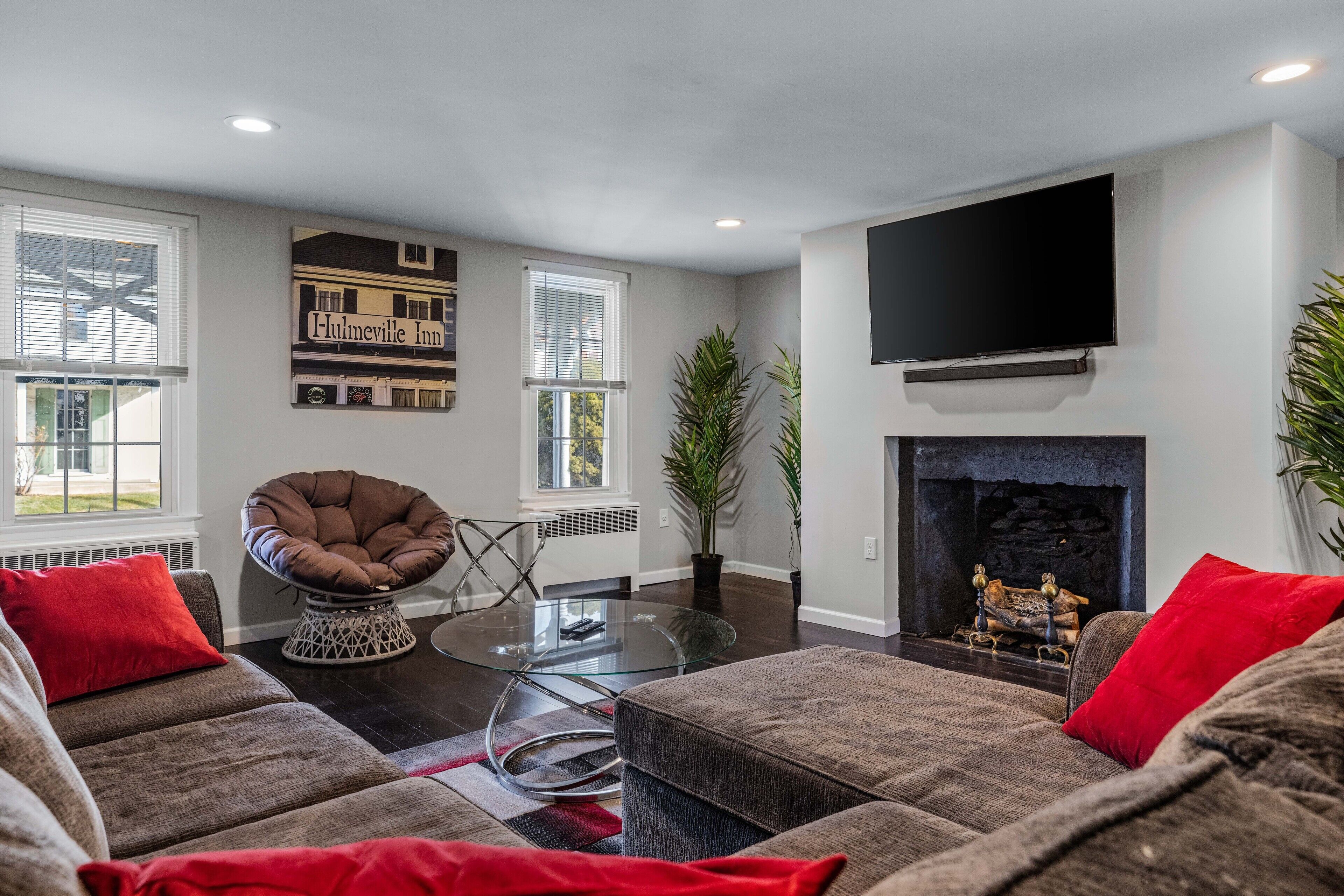 A modern living room with a fireplace, a flat-screen TV, and a cozy seating area.