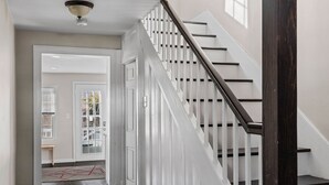 A staircase with white railings and dark wooden steps leading to a landing.