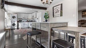 A modern kitchen with a central island, built-in appliances, and a chandelier.