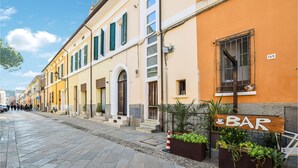 Une rue bordée d’immeubles, avec une enseigne de bar et un panneau indiquant le numéro 169.