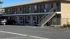 Ein mehrstöckiges Motel mit einer zentralen Treppe und einem Parkplatz.