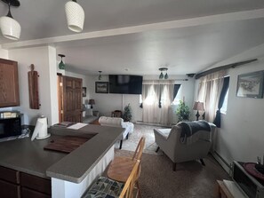 Un amplio salón con una isla de cocina, una mesa de comedor y un sofá.