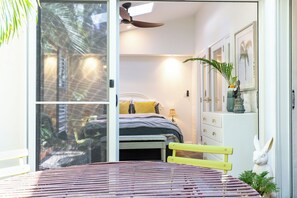 Een slaapkamer met een bed, een bankje, een dressoir en een raam.