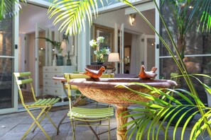 Een eetgedeelte met een ronde tafel, stoelen en decoratieve details.