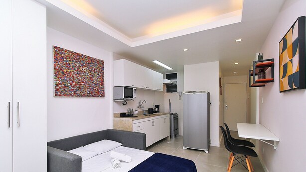 A compact room with a bed, a desk, a chair, a kitchenette, and a bathroom. - Rio Spot Homes Copacabana C059 (Rio de Janeiro)