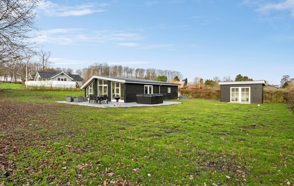 A modern house with a patio, a hot tub, and a small shed. - Gorgeous home in Rudkøbing with WiFi (Rudkøbing)