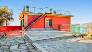 Un bâtiment rouge avec un escalier en pierre menant à un balcon.
