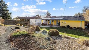 A residential property with a well-maintained garden, a covered patio, and a detached garage.