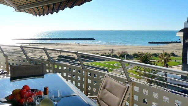 A balcony with a table, chairs, and a view of the beach and ocean. - Pretty 3 Room Apartment with 2 alcoves, AIRCON and WIFI, sea view, pool Rochelongue Cap d'Agde (LE CAP D AGDE)
