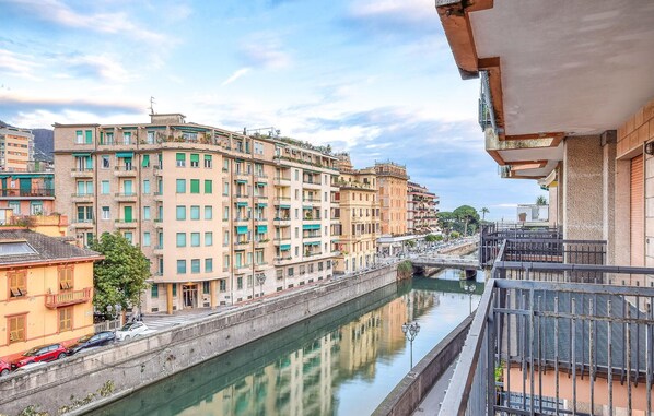Un canal bordé de bâtiments des deux côtés, un pont et un ciel dégagé.