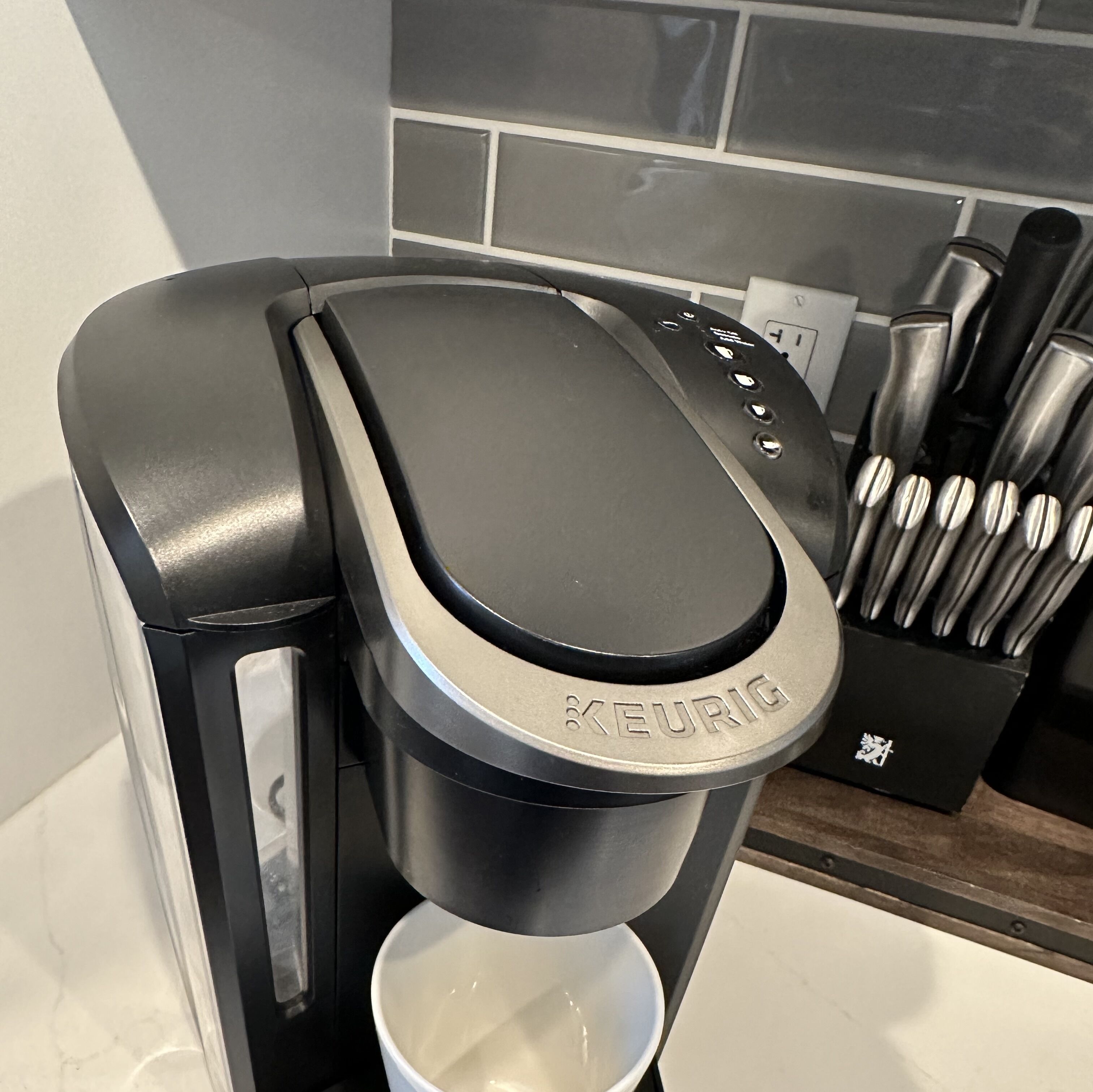 En Keurig kaffemaskine med drypbakke og en kaffekop.