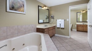 Un bagno con vasca, lavabo e uno specchio grande.